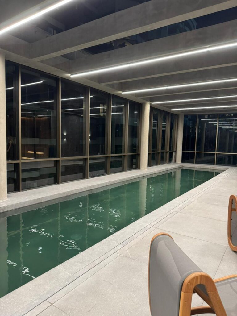 Piscina de 25 m do Park Avenue Ibirapuera, deck e vista. Foto real